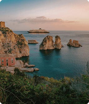 Coastal landscape with cruise ship at sunset.