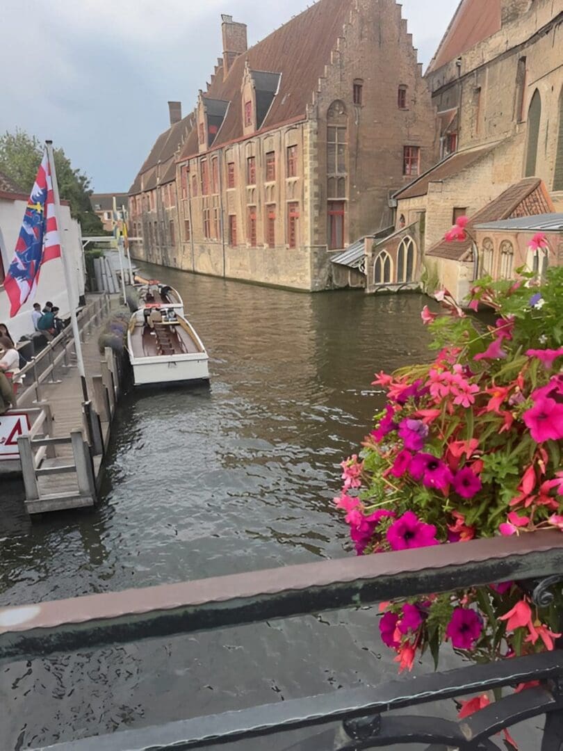 Canal boat with colorful flowers and buildings.